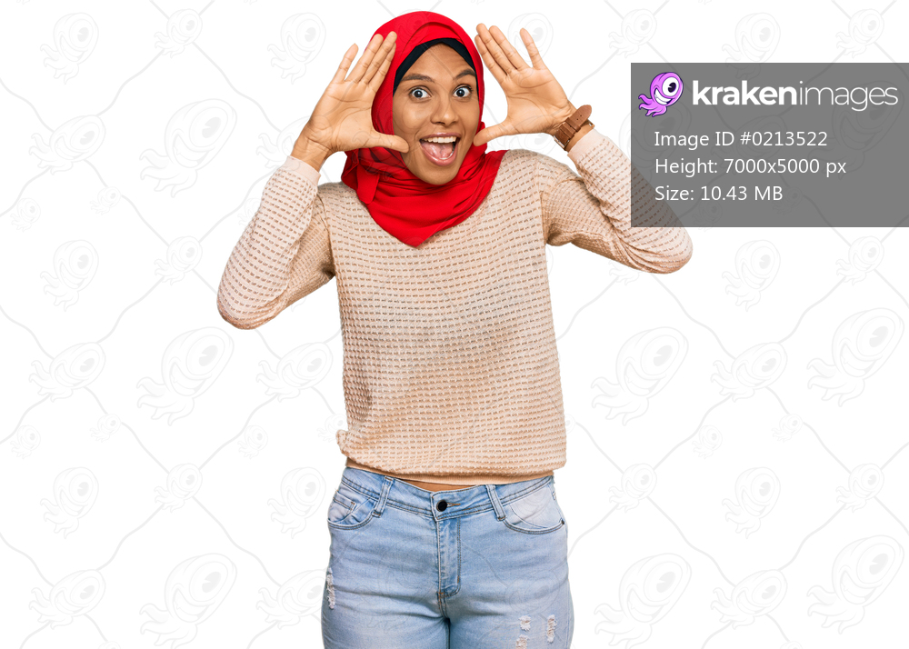 Young african american woman wearing traditional islamic hijab scarf smiling cheerful playing peek a boo with hands showing face. surprised and exited 