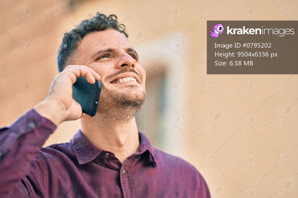 Young hispanic man smiling happy talking on the smartphone at the city.