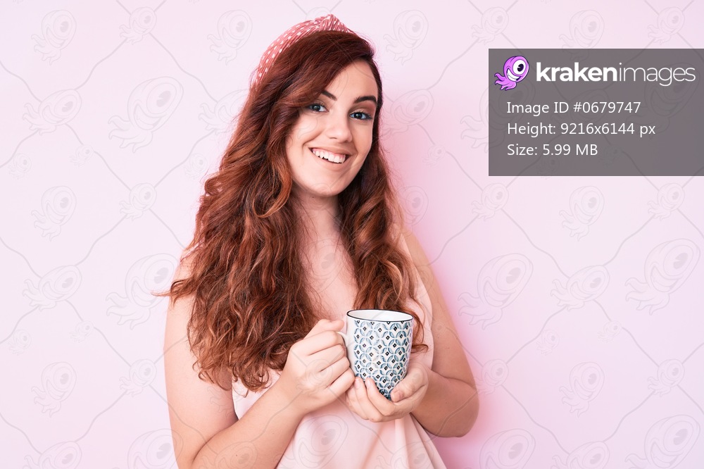Young beautiful woman holding coffee looking positive and happy standing and smiling with a confident smile showing teeth 