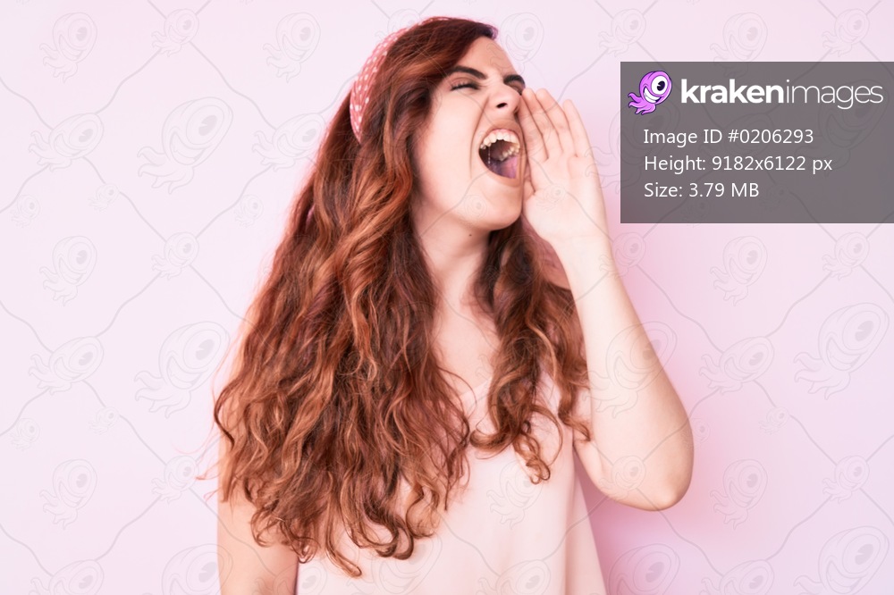 Young beautiful woman wearing casual clothes shouting and screaming loud to side with hand on mouth. communication concept. 