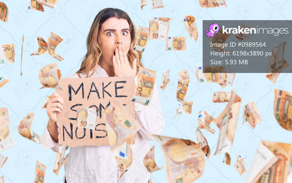 Young caucasian woman holding make some noise banner covering mouth with hand, shocked and afraid for mistake. surprised expression