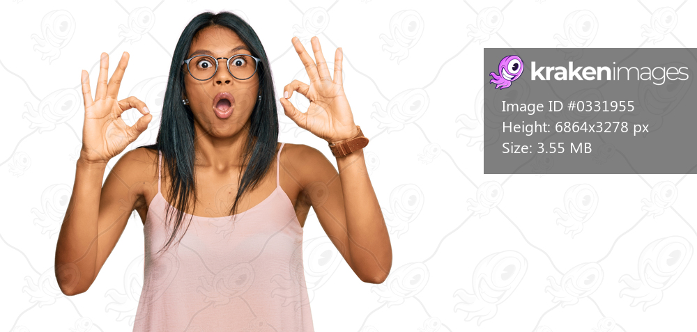 Young african american woman wearing casual clothes and glasses looking surprised and shocked doing ok approval symbol with fingers. crazy expression 