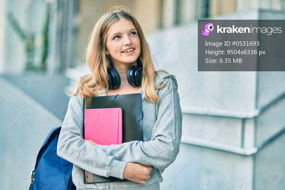 Beautiful caucasian student teenager smiling happy using headphones at the city.