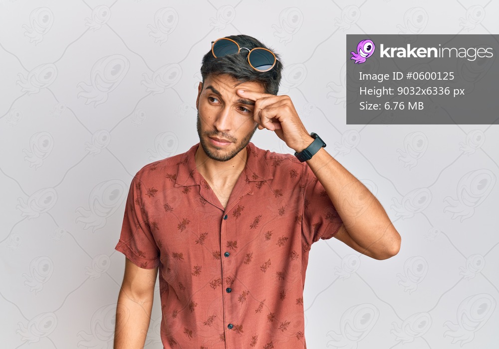 Young handsome man wearing casual summer clothes pointing unhappy to pimple on forehead, ugly infection of blackhead. acne and skin problem 
