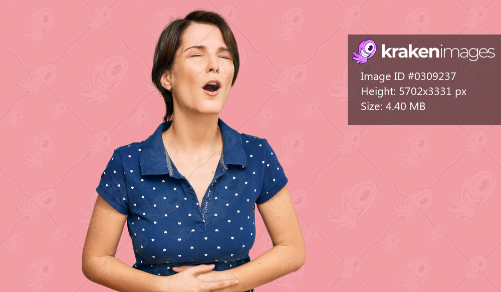Young brunette woman with short hair wearing casual clothes with hand on stomach because nausea, painful disease feeling unwell. ache concept. 