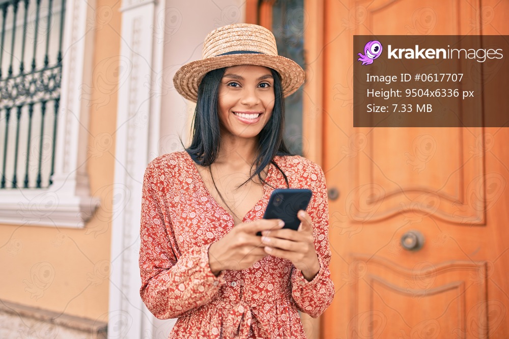 Young african american tourist woman on vacation smiling happy using smartphone at the city.