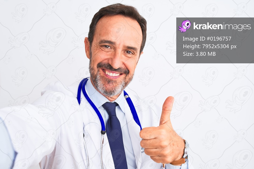 Middle age doctor man wearing stethoscope make selfie over isolated white background happy with big smile doing ok sign, thumb up with fingers, excellent sign