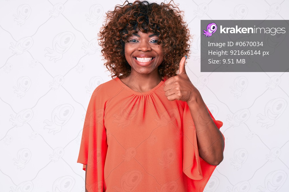 Young african american woman wearing casual clothes smiling happy and positive, thumb up doing excellent and approval sign 