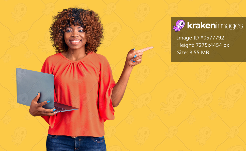 Young african american woman working using computer laptop smiling happy pointing with hand and finger to the side 