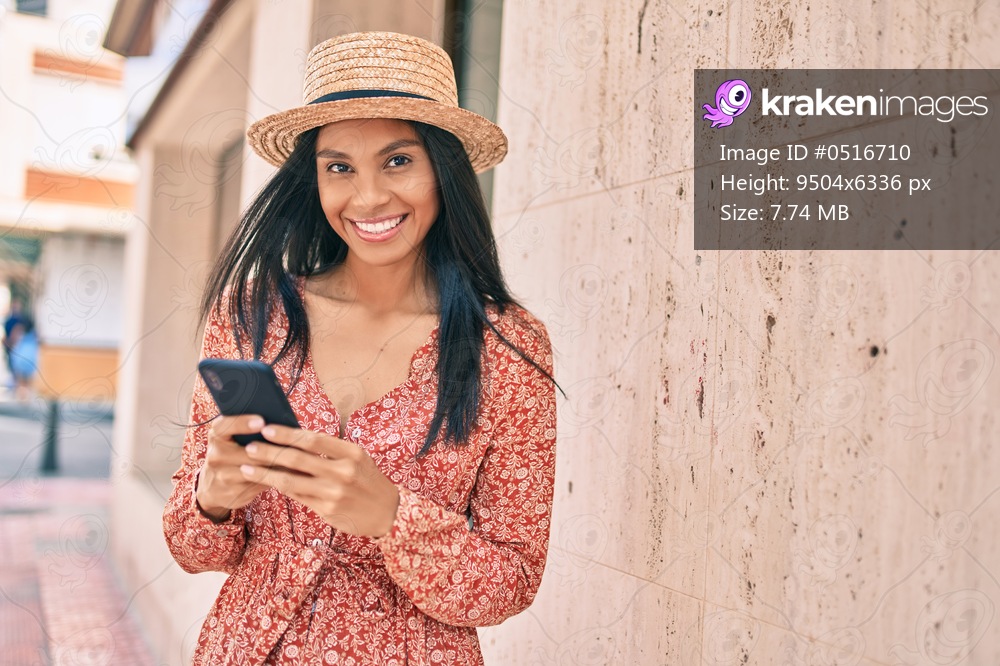 Young african american tourist woman on vacation smiling happy using smartphone at the city.