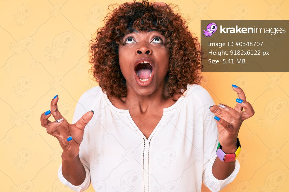Young african american woman wearing casual clothes crazy and mad shouting and yelling with aggressive expression and arms raised. frustration concept. 