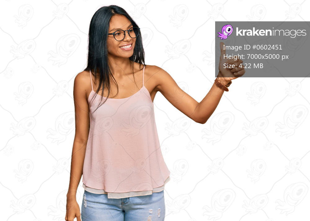 Young african american woman wearing casual clothes and glasses looking proud, smiling doing thumbs up gesture to the side 