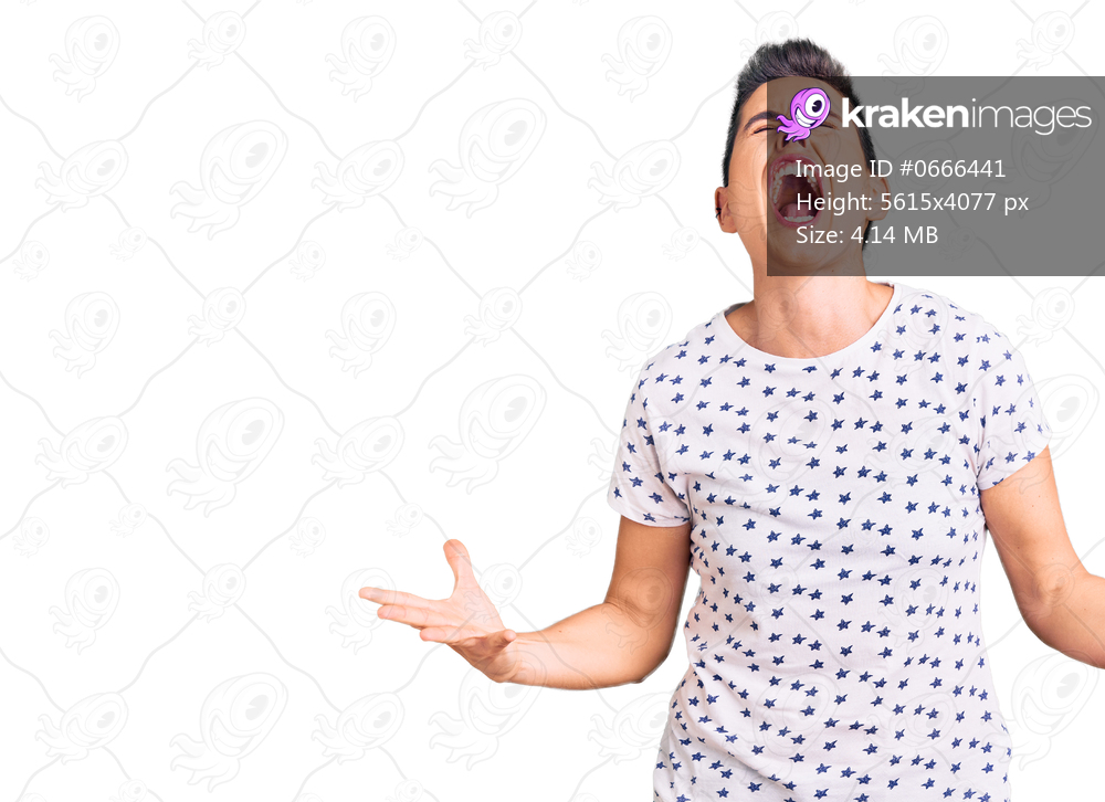 Young woman with short hair wearing casual clothes crazy and mad shouting and yelling with aggressive expression and arms raised. frustration concept. 