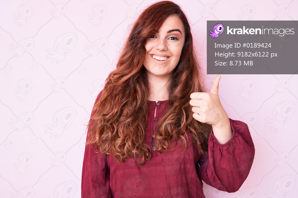 Young beautiful woman wearing casual winter sweater smiling happy and positive, thumb up doing excellent and approval sign 