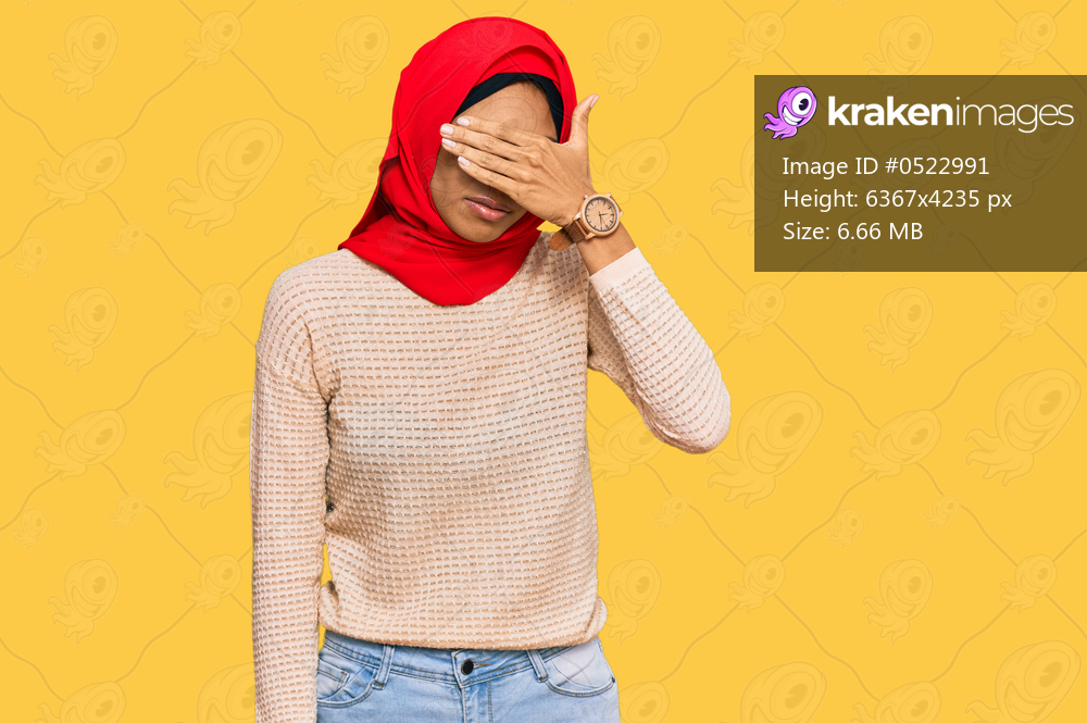 Young african american woman wearing traditional islamic hijab scarf covering eyes with hand, looking serious and sad. sightless, hiding and rejection concept 