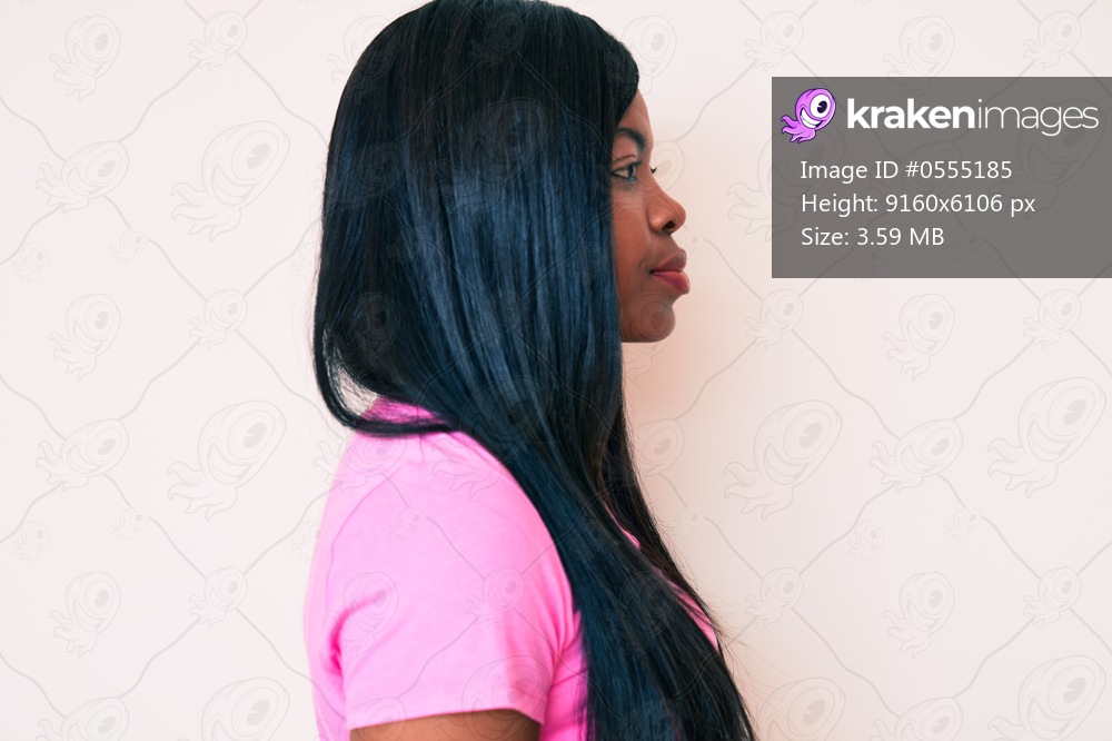Young african american woman wearing casual clothes looking to side, relax profile pose with natural face with confident smile. 