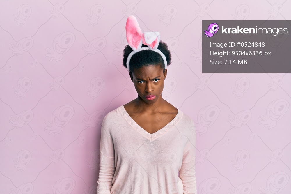 Young african american girl wearing cute easter bunny ears skeptic and nervous, frowning upset because of problem. negative person. 