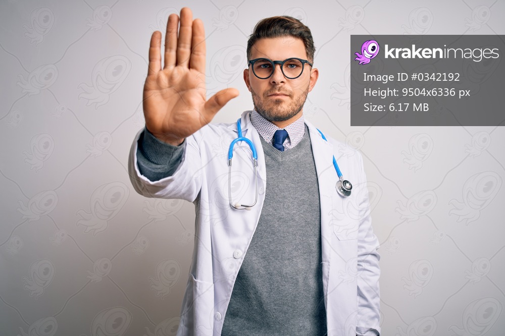 Young doctor man with blue eyes wearing medical coat and stethoscope over isolated background doing stop sing with palm of the hand. Warning expression with negative and serious gesture on the face.