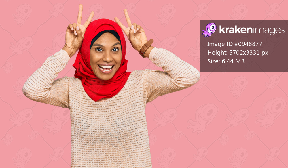 Young african american woman wearing traditional islamic hijab scarf posing funny and crazy with fingers on head as bunny ears, smiling cheerful 