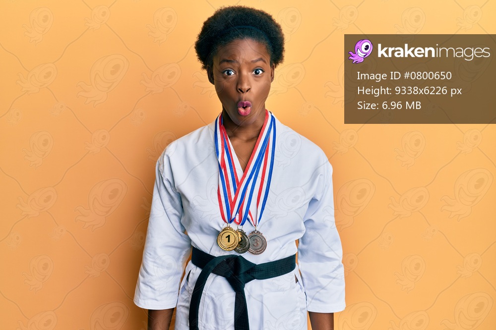 Young african american girl wearing karate kimono and black belt scared and amazed with open mouth for surprise, disbelief face 