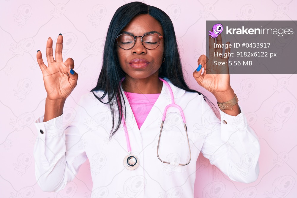 Young african american woman wearing doctor stethoscope relax and smiling with eyes closed doing meditation gesture with fingers. yoga concept. 