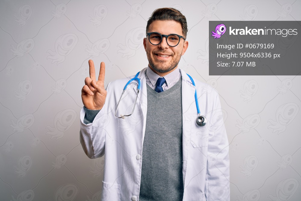 Young doctor man with blue eyes wearing medical coat and stethoscope over isolated background showing and pointing up with fingers number two while smiling confident and happy.