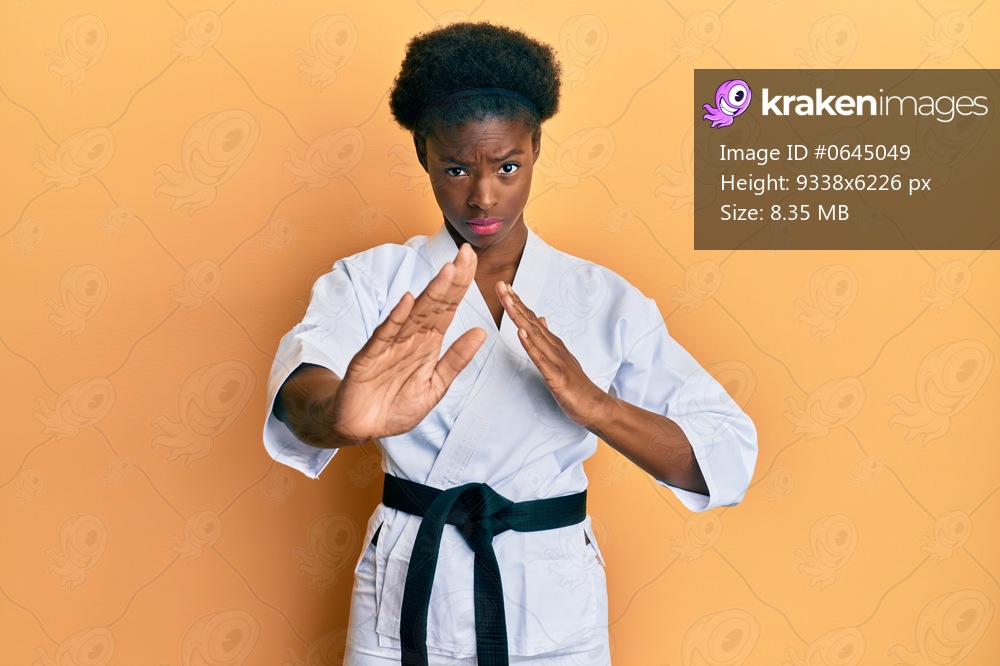 Young african american girl wearing karate kimono and black belt skeptic and nervous, frowning upset because of problem. negative person. 