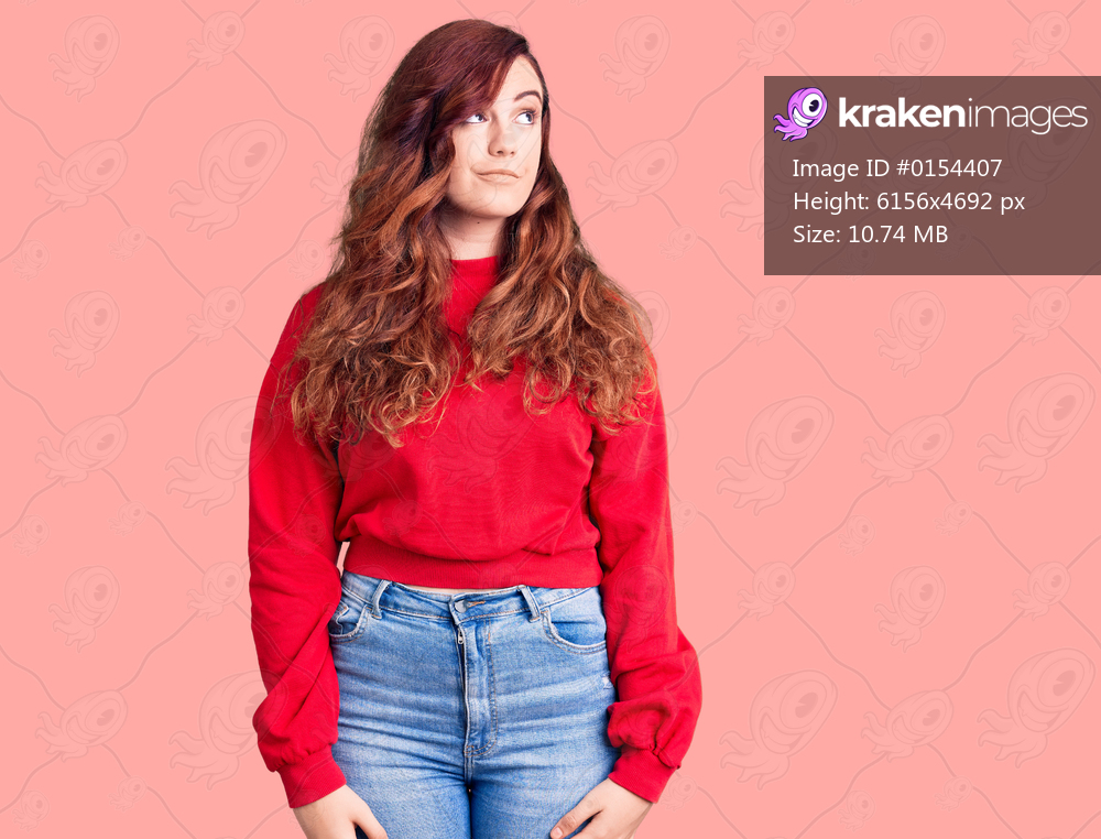 Young beautiful woman wearing casual winter sweater smiling looking to the side and staring away thinking. 