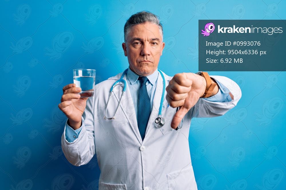 Middle age handsome grey-haired doctor man drinking glass of water over blue background with angry face, negative sign showing dislike with thumbs down, rejection concept