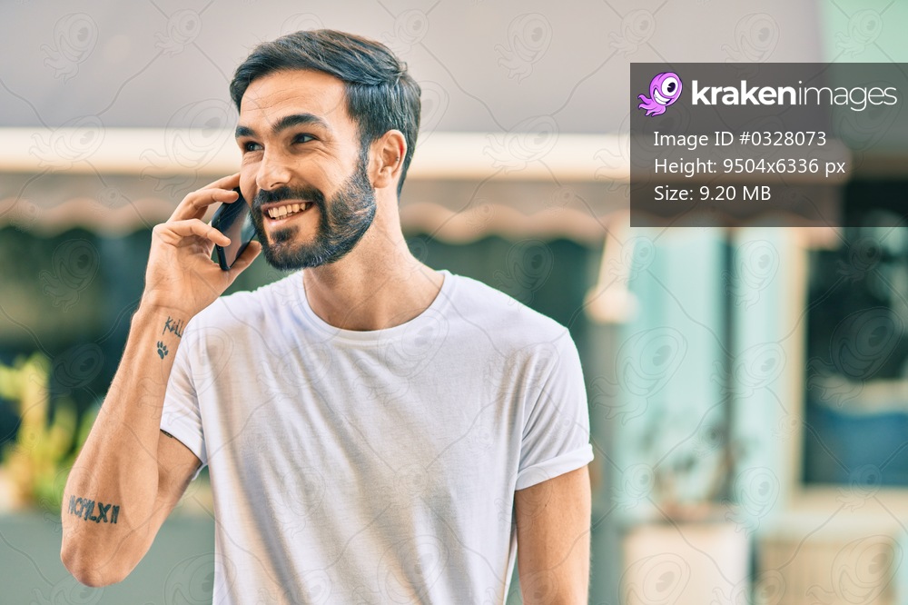 Young hispanic man smiling happy talking on the smartphone at the city.