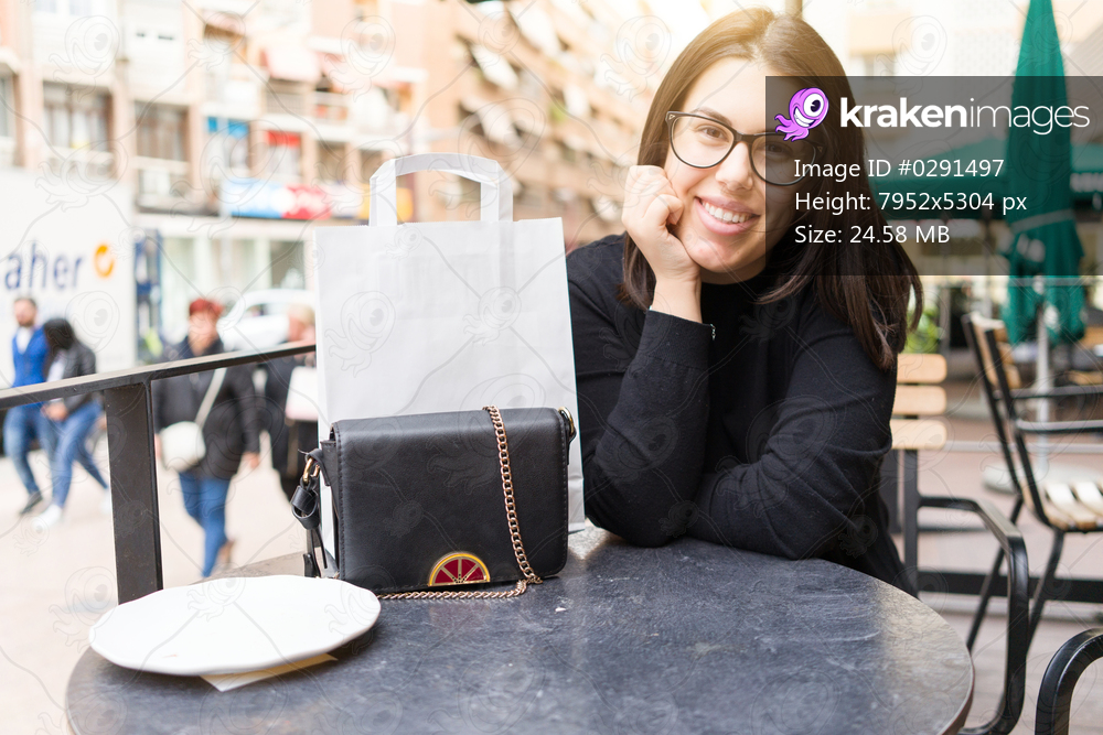Beautiful young woman smiling happy sitting at the cafeteria of the town