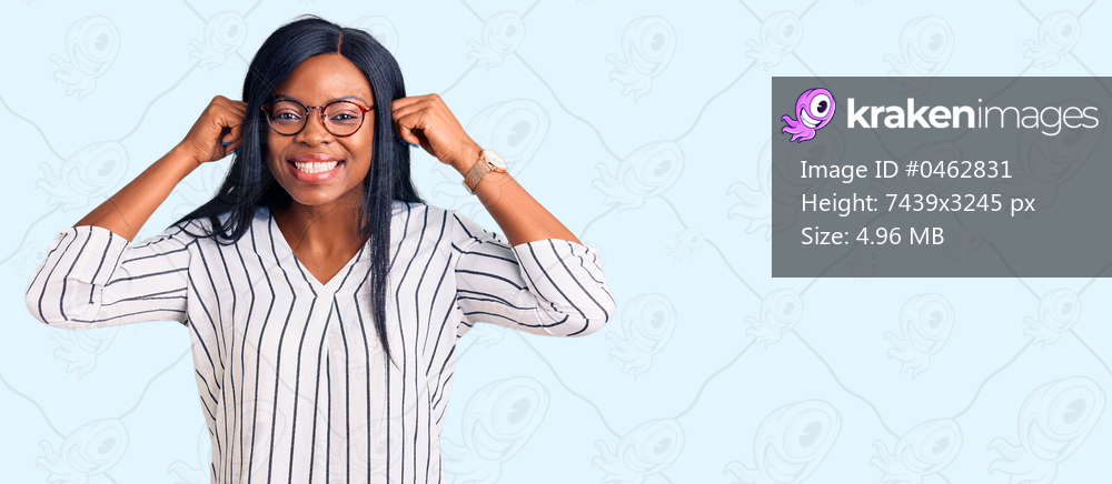 Young african american woman wearing casual clothes and glasses smiling pulling ears with fingers, funny gesture. audition problem 