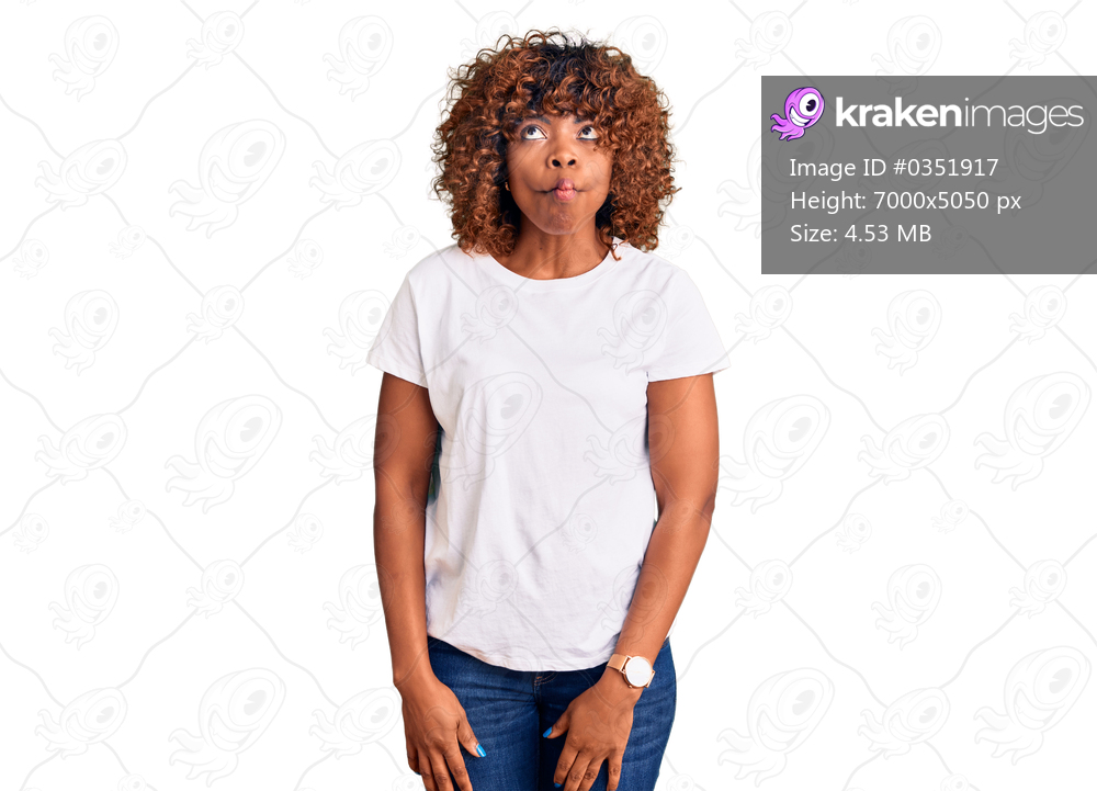 Young african american woman wearing casual white tshirt making fish face with lips, crazy and comical gesture. funny expression. 