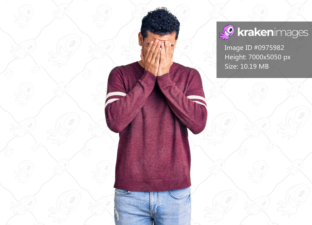 Hispanic handsome young man wearing casual clothes with sad expression covering face with hands while crying. depression concept. 