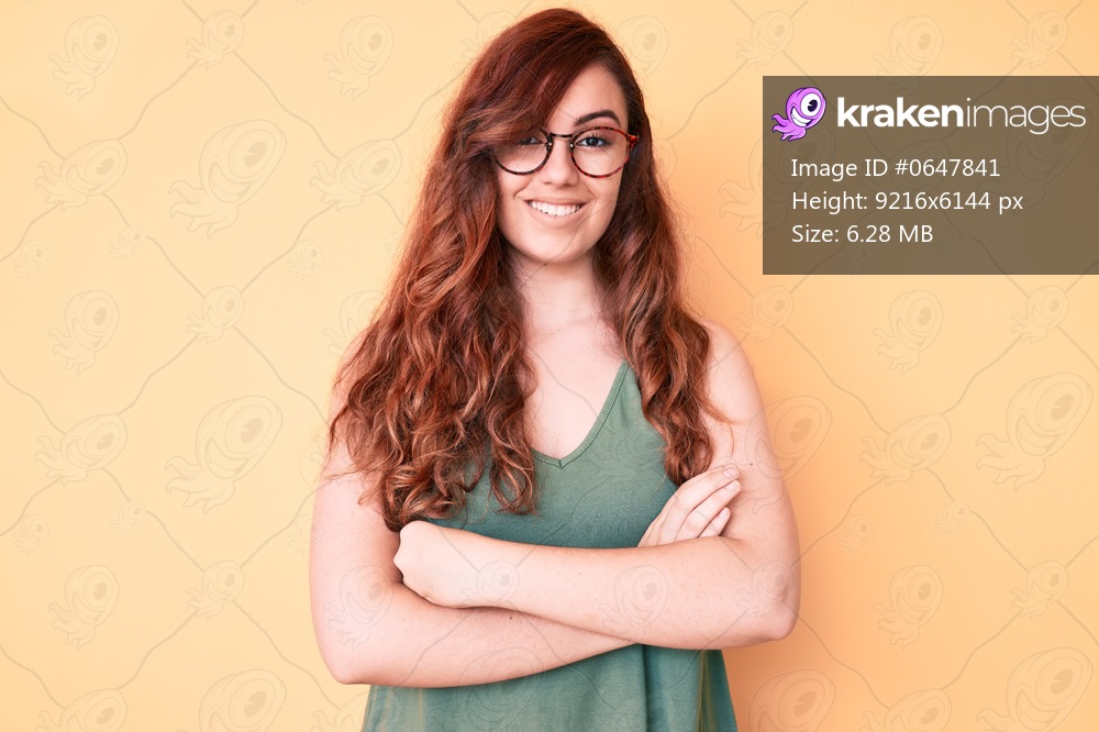 Young beautiful woman wearing casual clothes and glasses happy face smiling with crossed arms looking at the camera. positive person. 