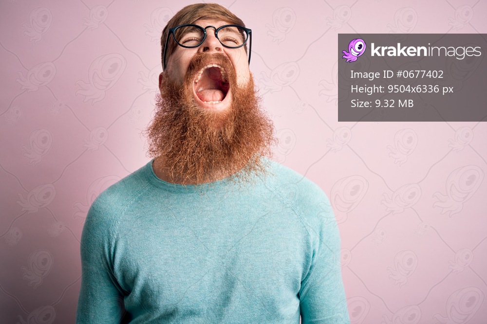 Handsome Irish redhead man with beard wearing glasses over pink isolated background angry and mad screaming frustrated and furious, shouting with anger. Rage and aggressive concept.