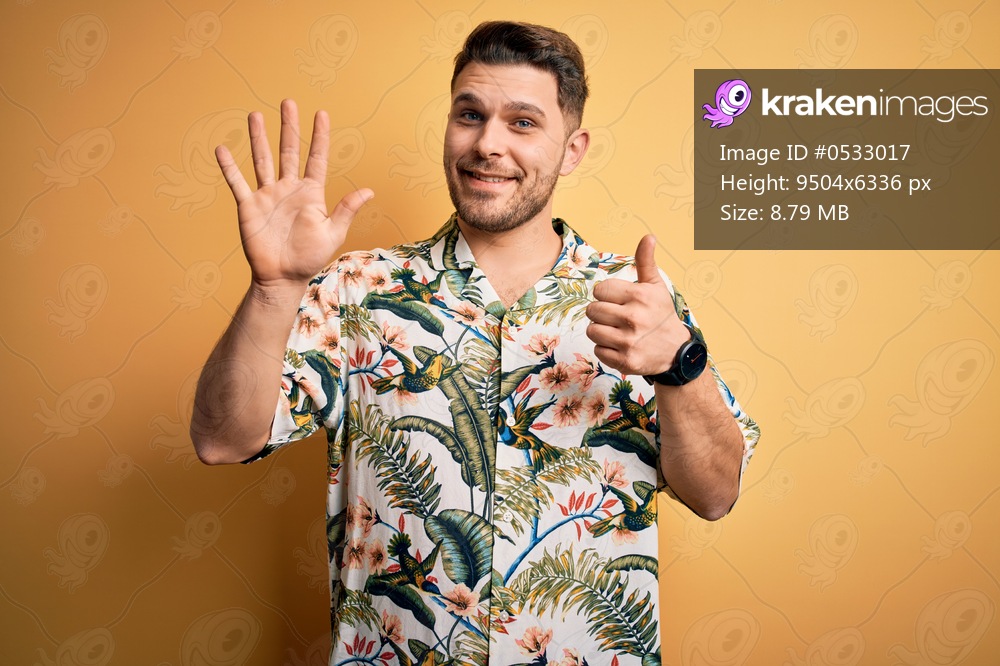 Young man with blue eyes on vacation wearing floral summer shirt over yellow background showing and pointing up with fingers number six while smiling confident and happy.