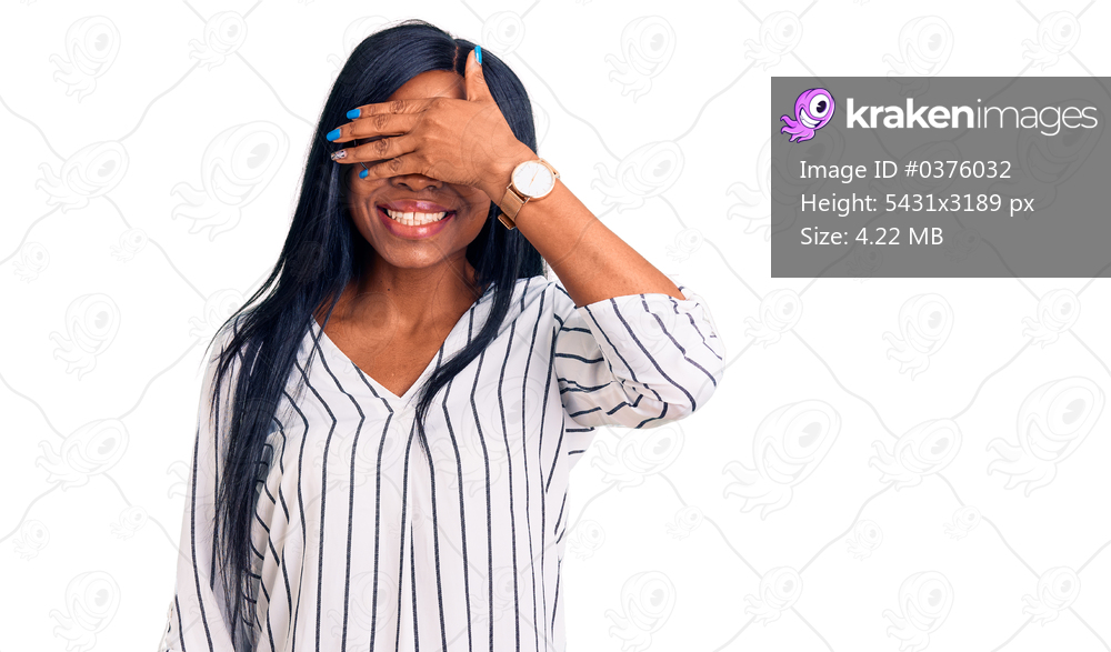 Young african american woman wearing casual clothes and glasses smiling and laughing with hand on face covering eyes for surprise. blind concept. 