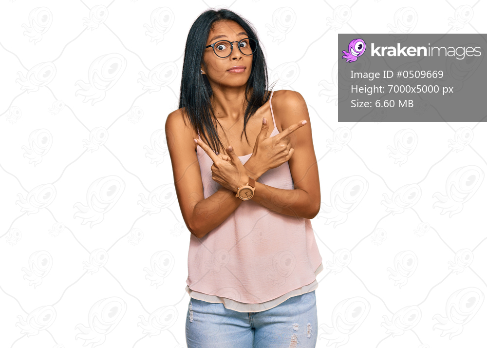Young african american woman wearing casual clothes and glasses pointing to both sides with fingers, different direction disagree 