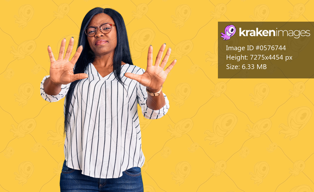 Young african american woman wearing casual clothes and glasses afraid and terrified with fear expression stop gesture with hands, shouting in shock. panic concept. 