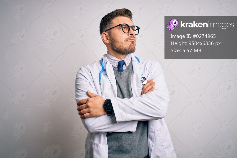 Young doctor man with blue eyes wearing medical coat and stethoscope over isolated background looking to the side with arms crossed convinced and confident