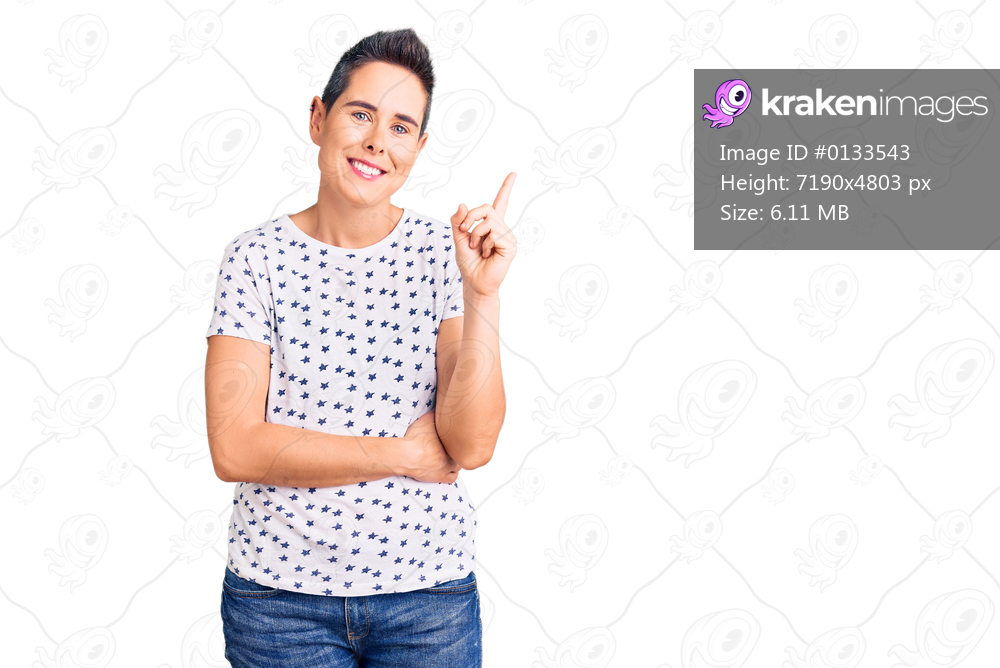 Young woman with short hair wearing casual clothes smiling happy pointing with hand and finger to the side 