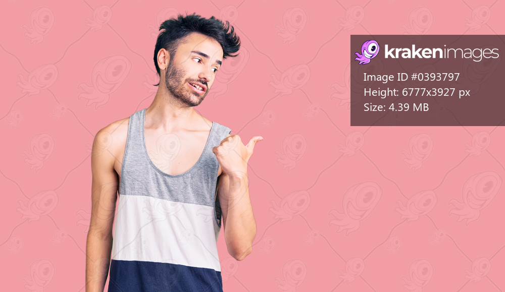 Young hispanic man wearing casual clothes smiling with happy face looking and pointing to the side with thumb up. 