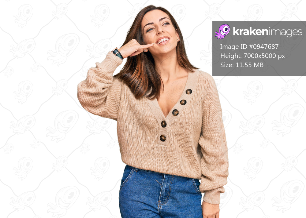 Young brunette woman wearing casual winter sweater smiling doing phone gesture with hand and fingers like talking on the telephone. communicating concepts. 