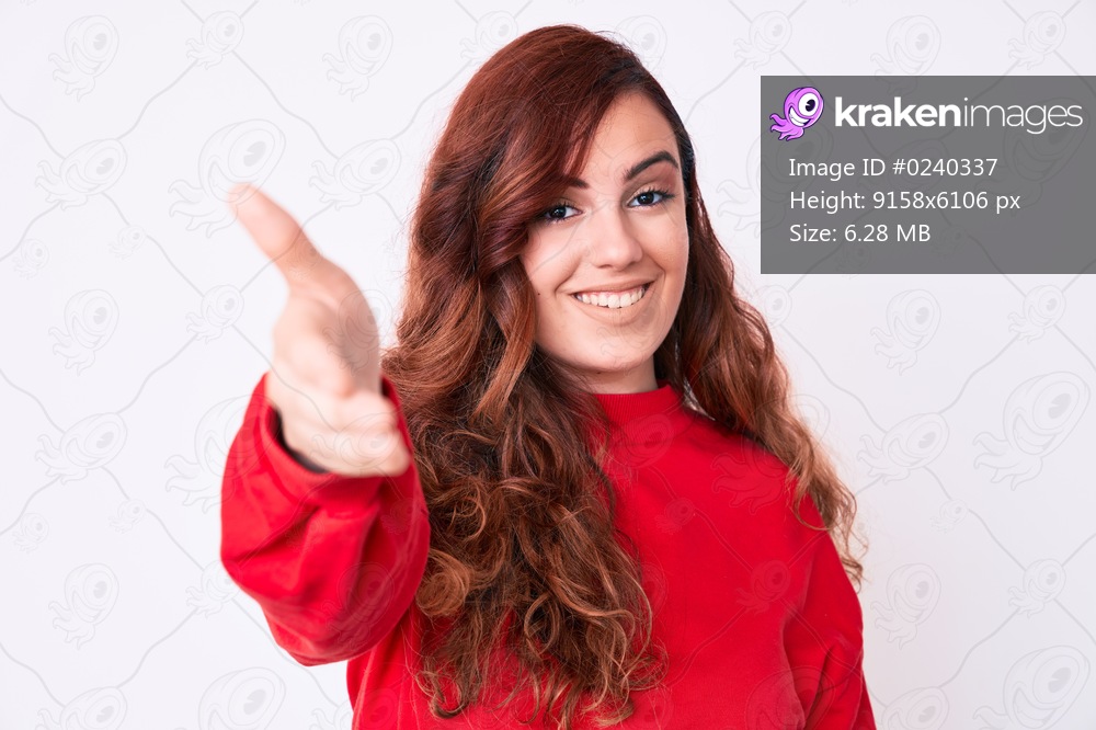 Young beautiful woman wearing casual clothes smiling friendly offering handshake as greeting and welcoming. successful business. 