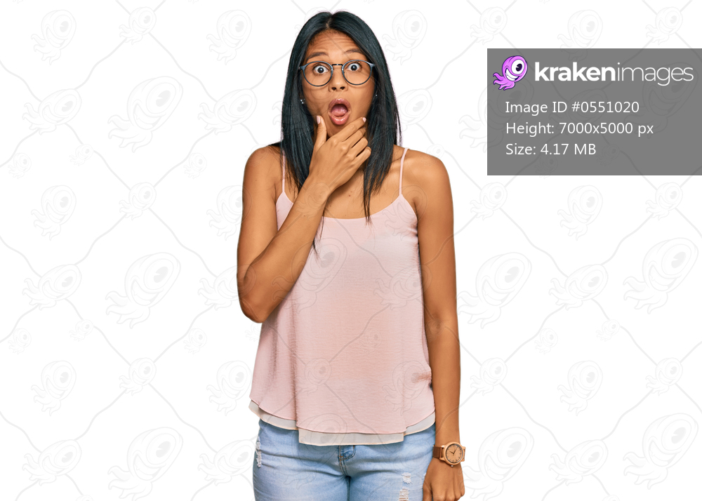 Young african american woman wearing casual clothes and glasses looking fascinated with disbelief, surprise and amazed expression with hands on chin 