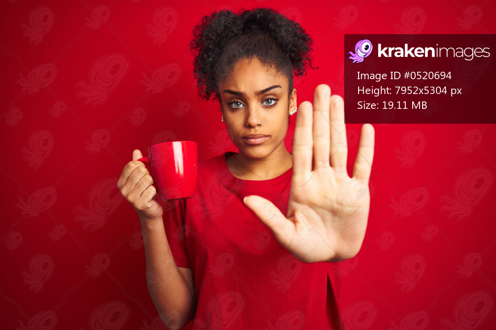 Young african american woman drinking a cup of coffee over isolated red background with open hand doing stop sign with serious and confident expression, defense gesture