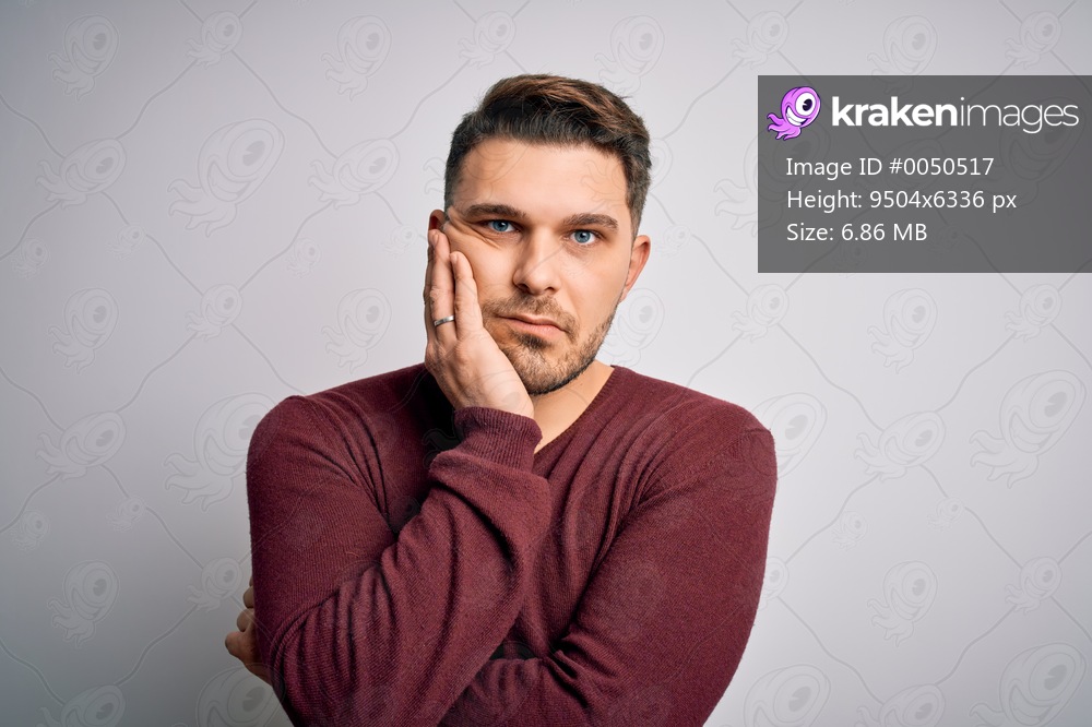 Young man with blue eyes wearing casual sweater standing over isolated background thinking looking tired and bored with depression problems with crossed arms.