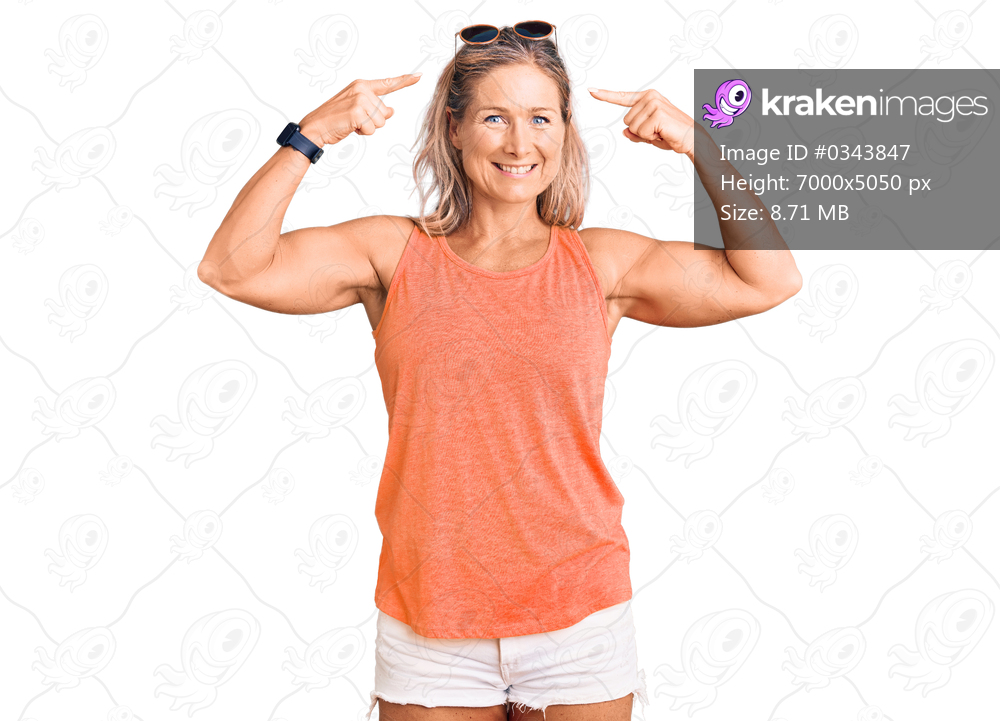 Middle age fit blonde woman wearing casual summer clothes and sunglasses smiling pointing to head with both hands finger, great idea or thought, good memory 