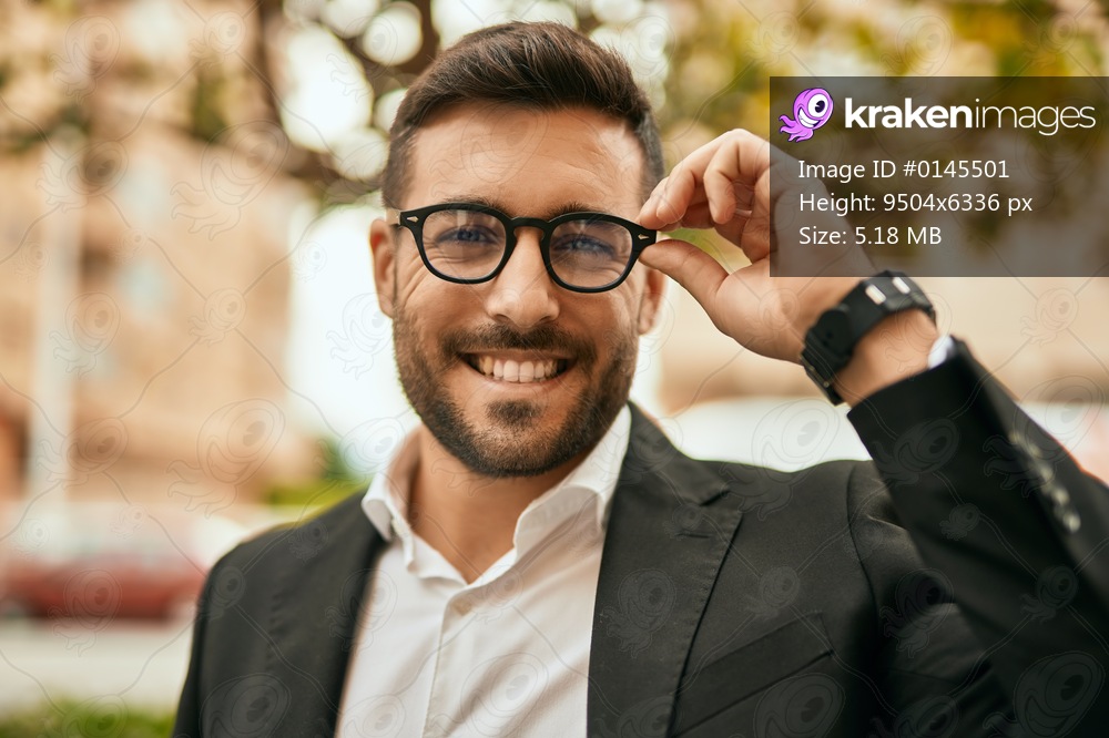 Young hispanic businessman smiling happy standing at the city.